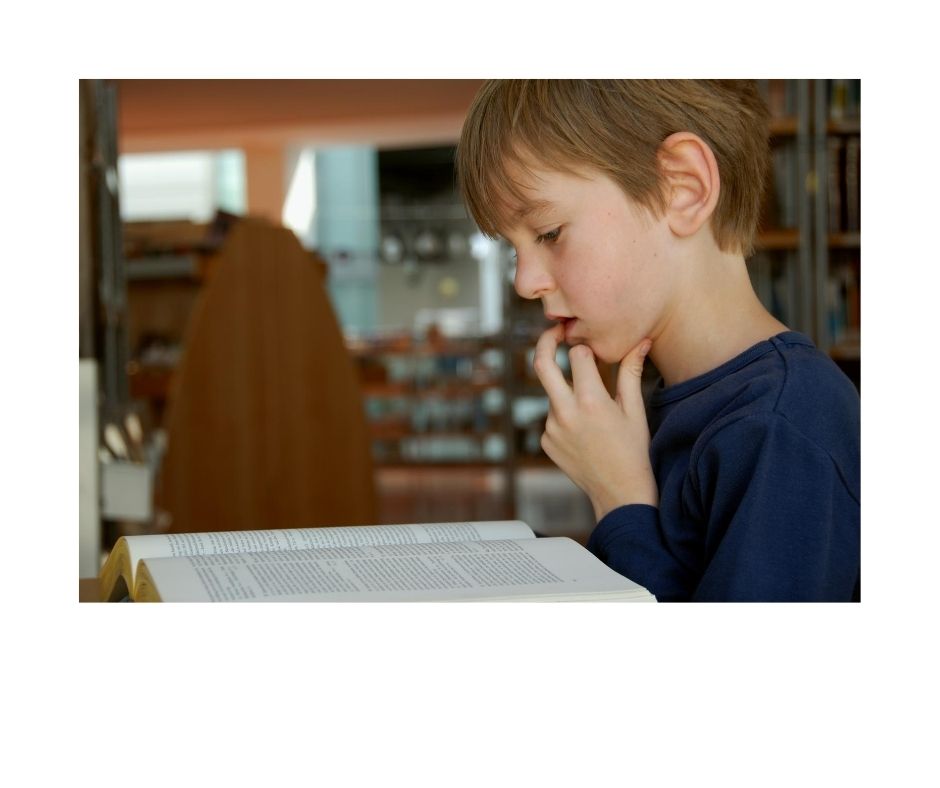 kid looking up words in book