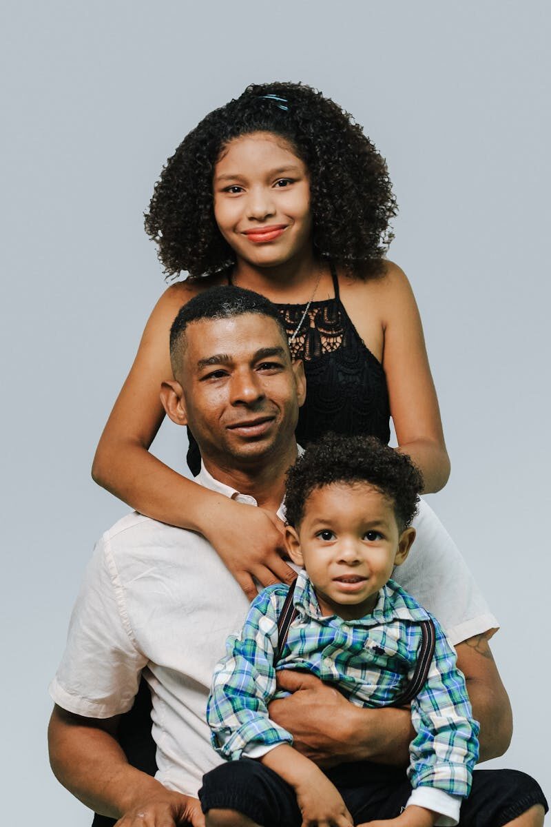 Father with daughter and son in a cheerful studio family portrait on white background.