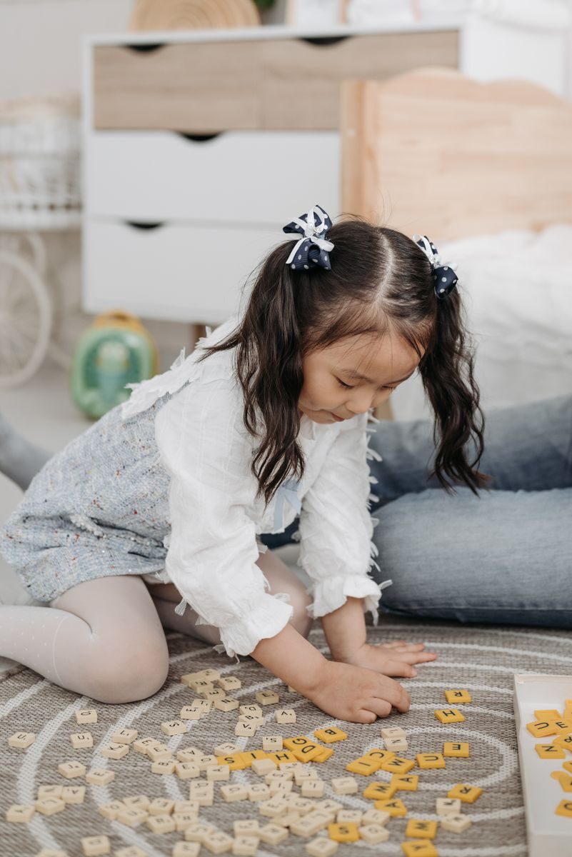 Child playing with letter tiles provided by Orton Gillingham Tutors in San Diego, CA.
